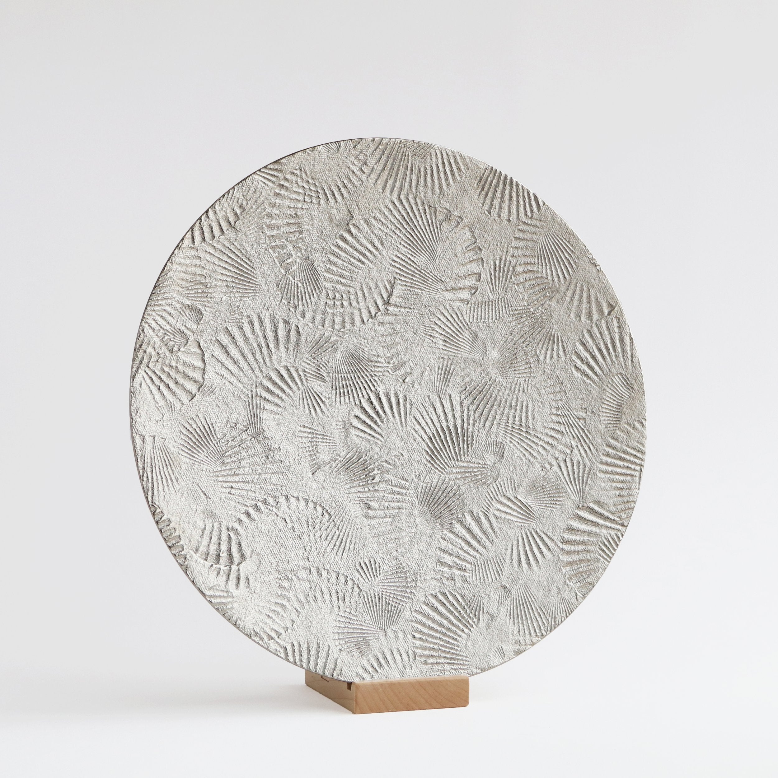 large round silver metal platter on stand