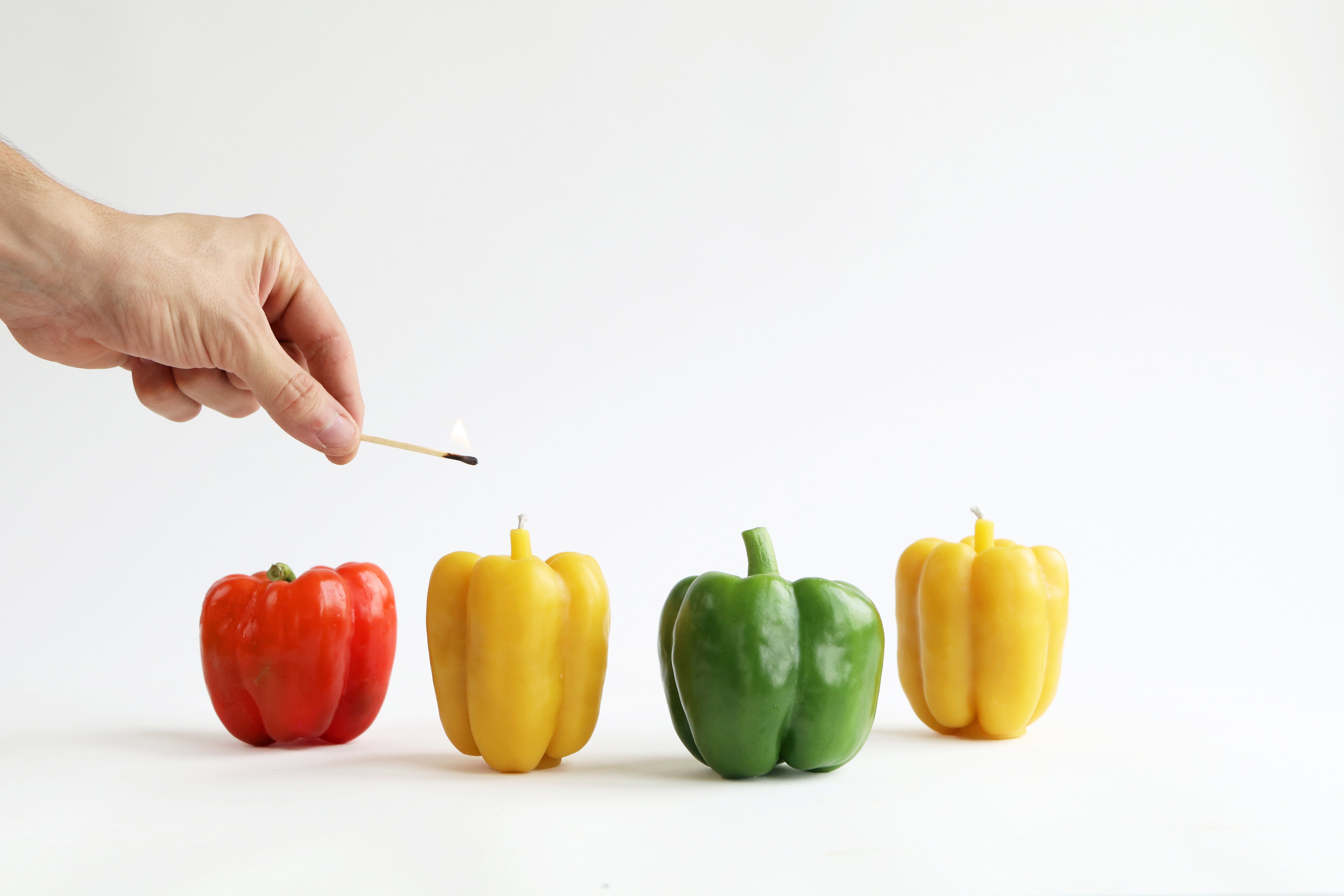 Hand lighting pepper beeswax candle