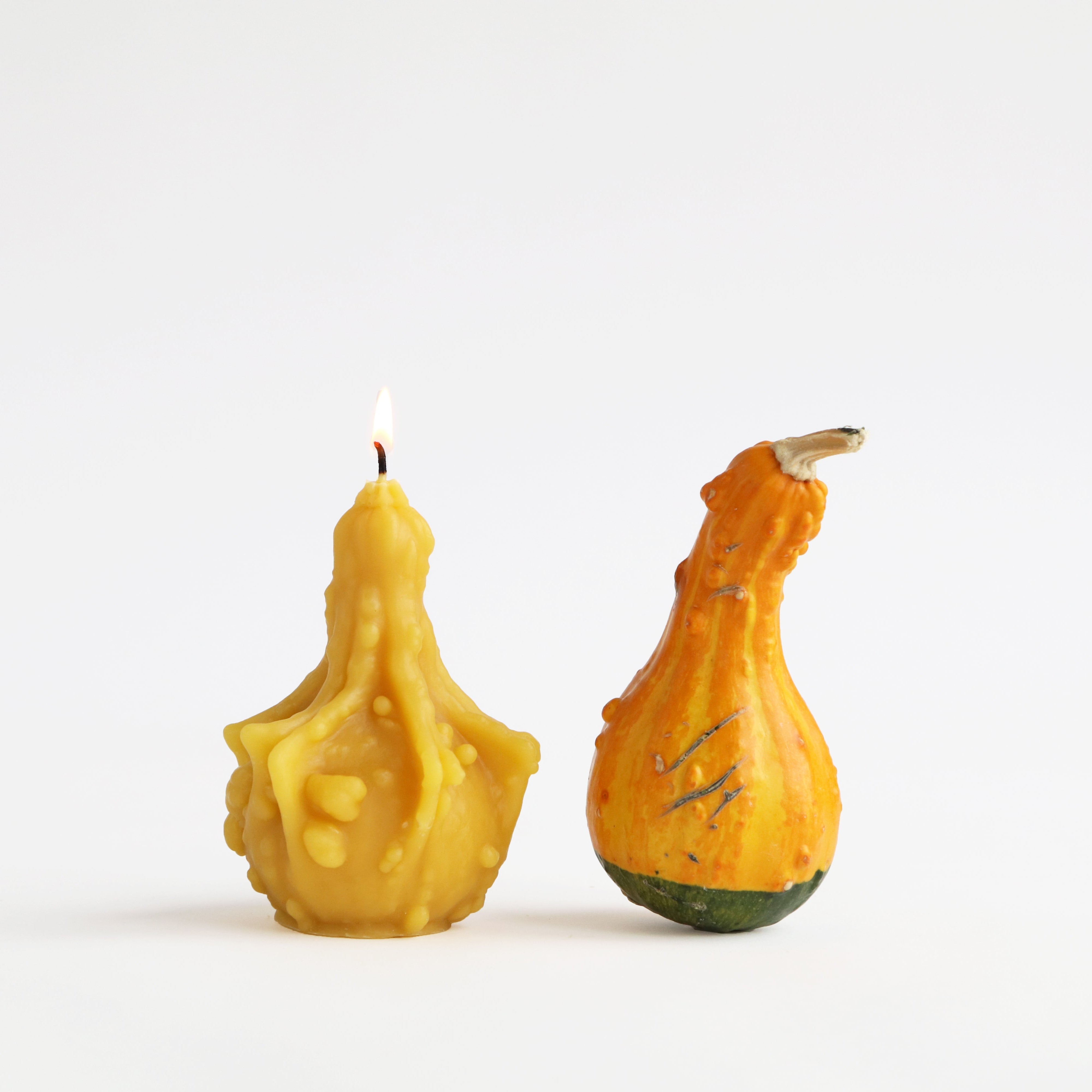 lit gourd candle next to fall decor