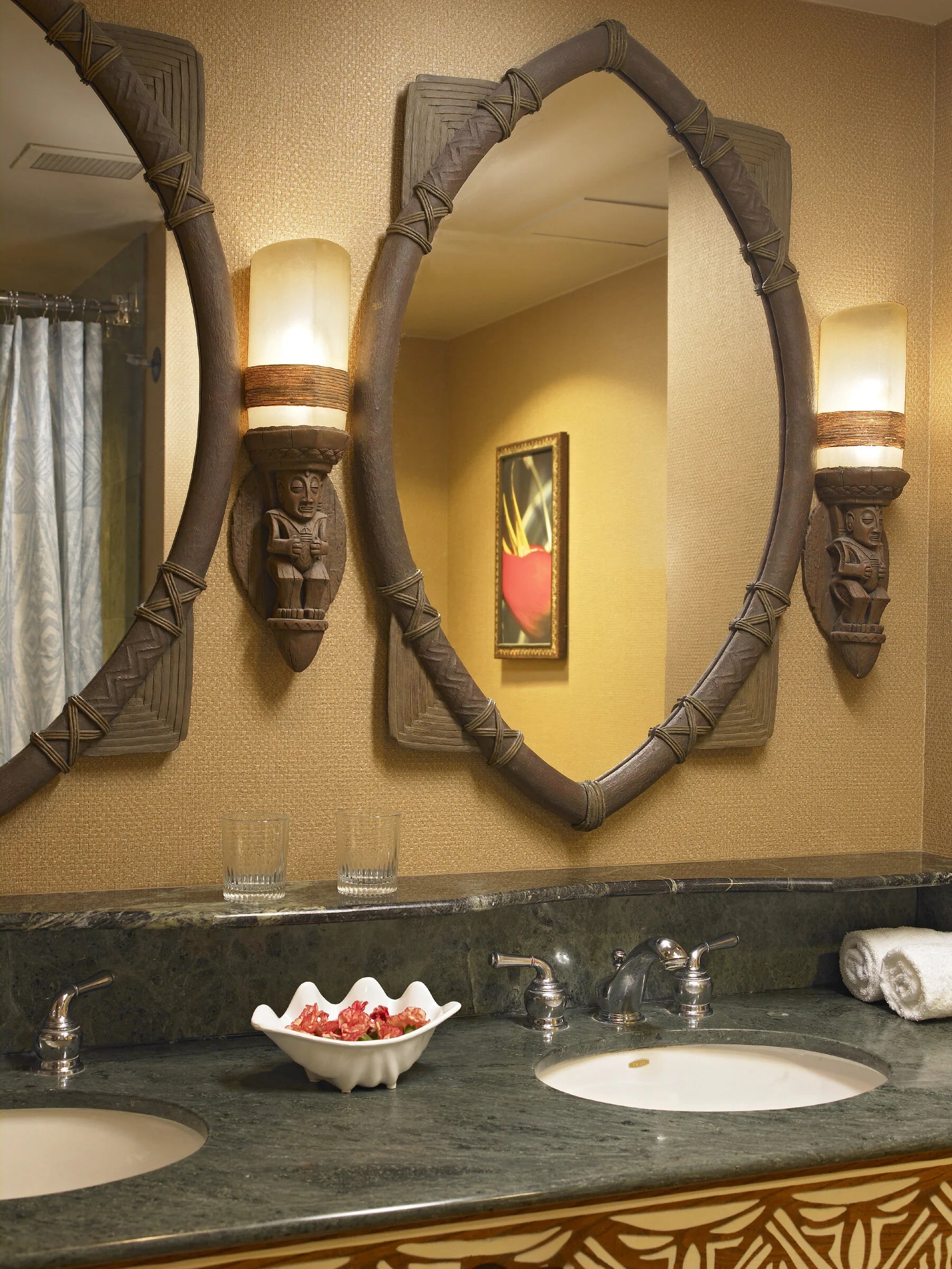 Bathroom vanity with decorative mirrors and a bowl of fruit on the counter.