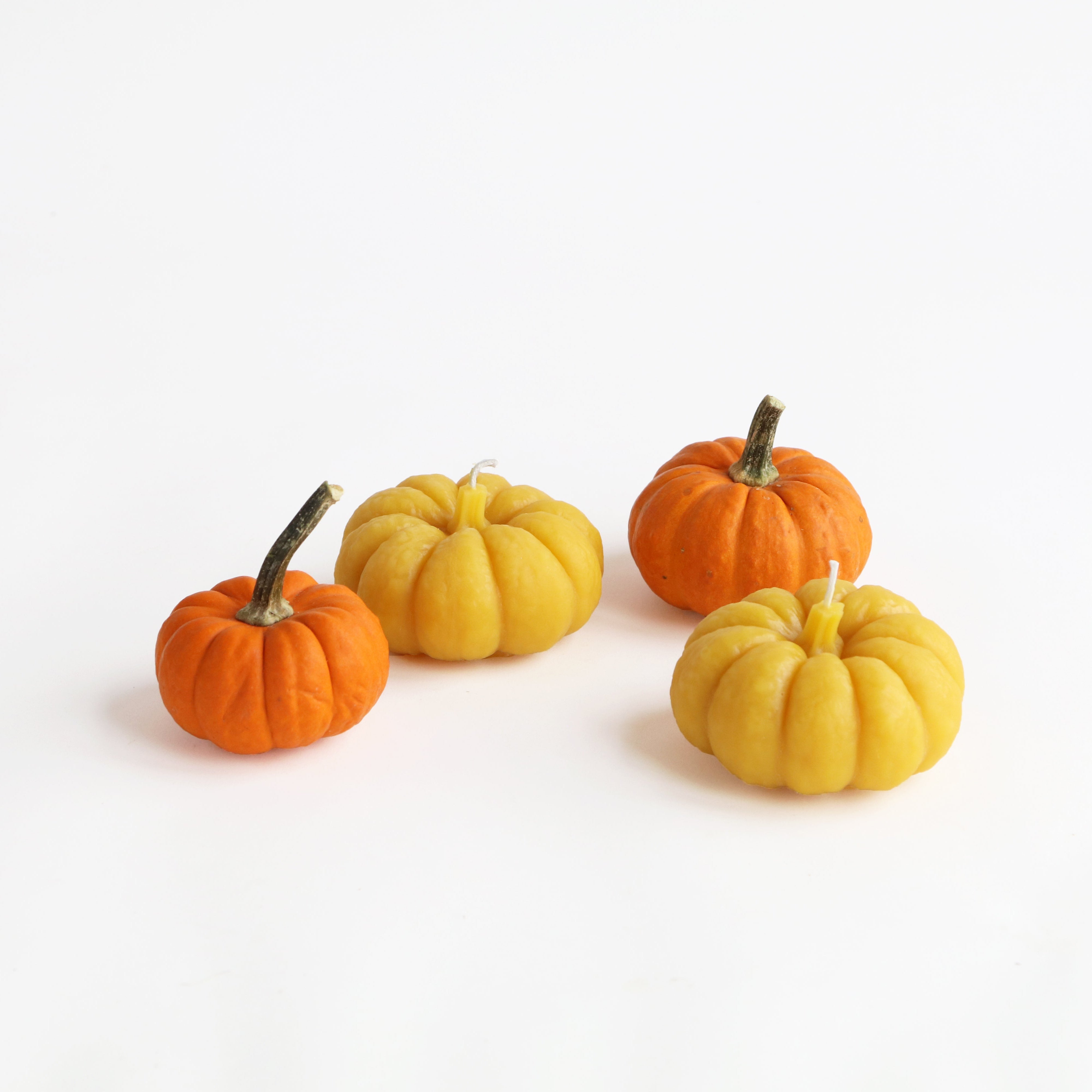 two pumpkin candles and two pumpkins