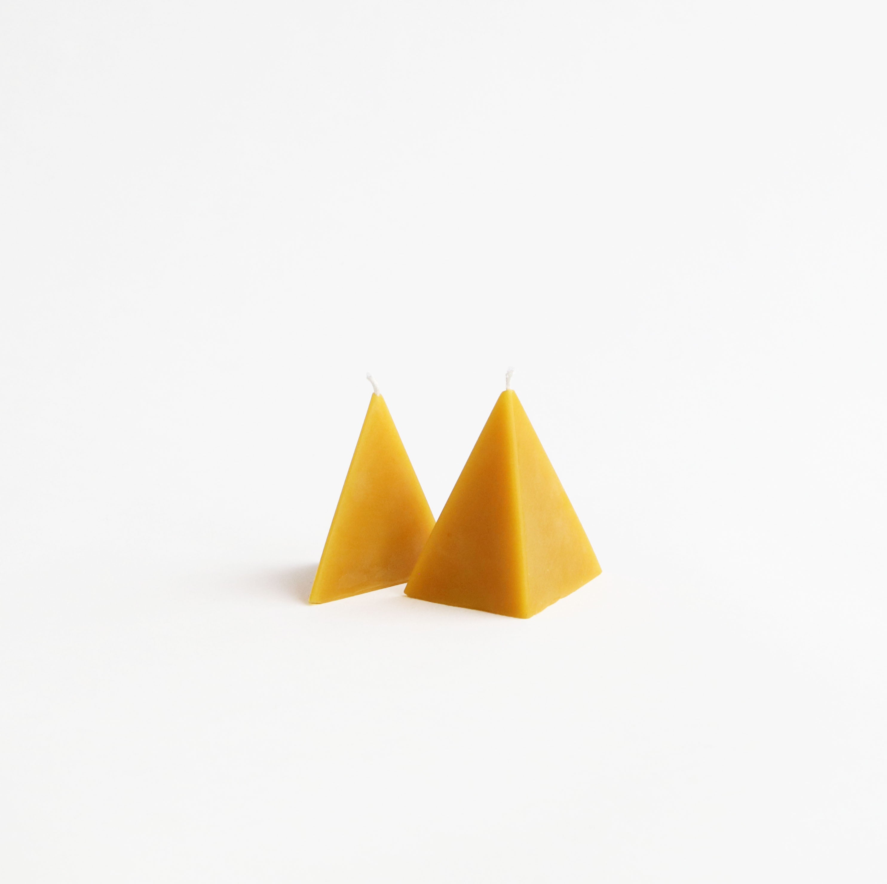 Two yellow pyramid-shaped objects on a white background
