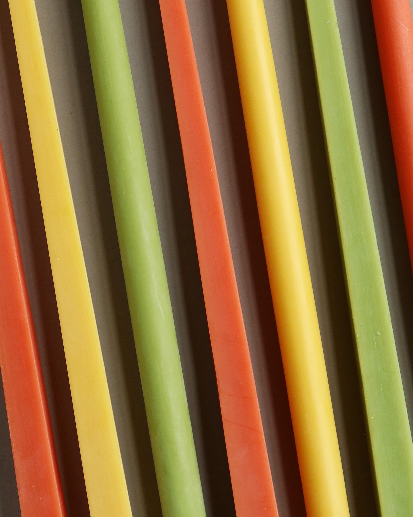 Close-up of colorful candles in orange, green, and yellow.