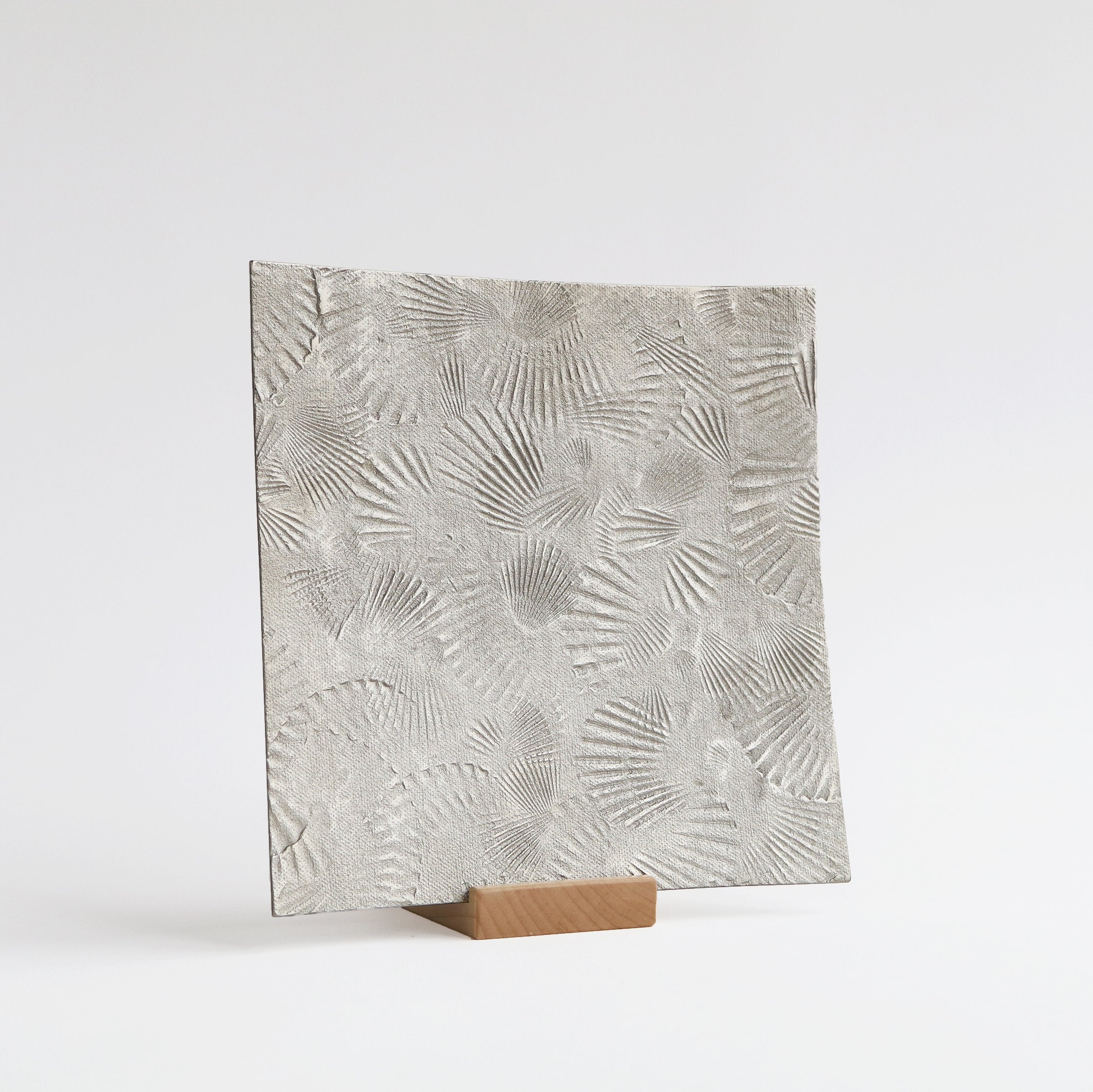 silver serving platter with scallop texture of wood stand