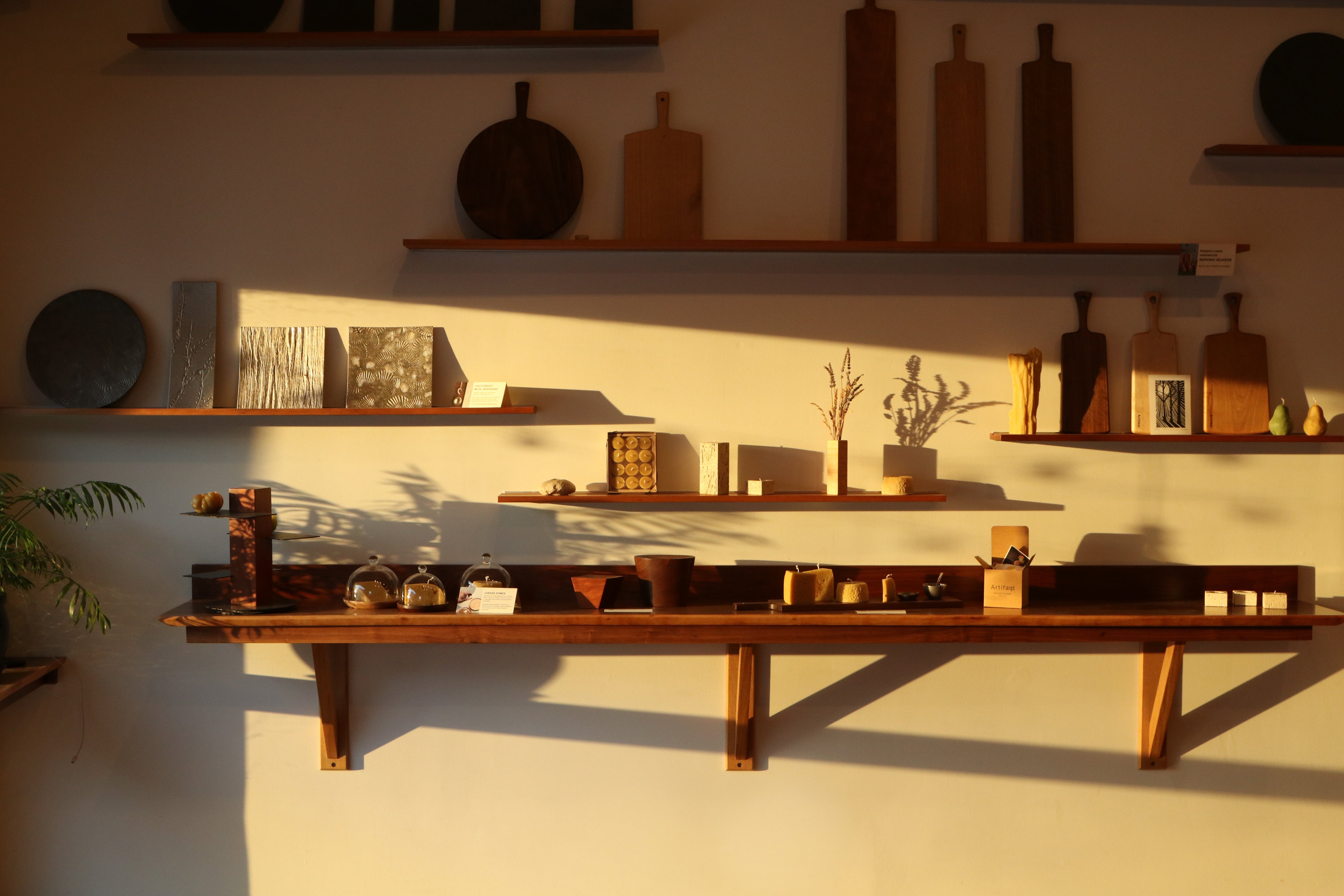 Wooden shelves with various items against a white wall
