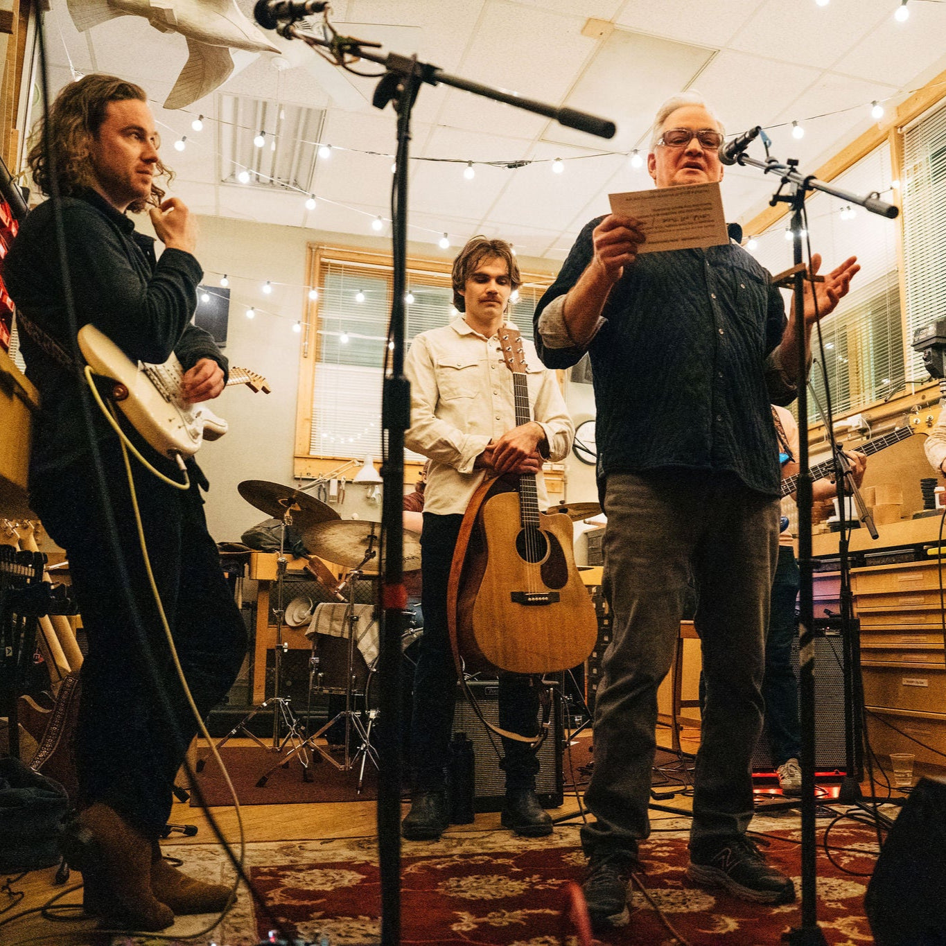 Band playing music in a studio with musical instruments around