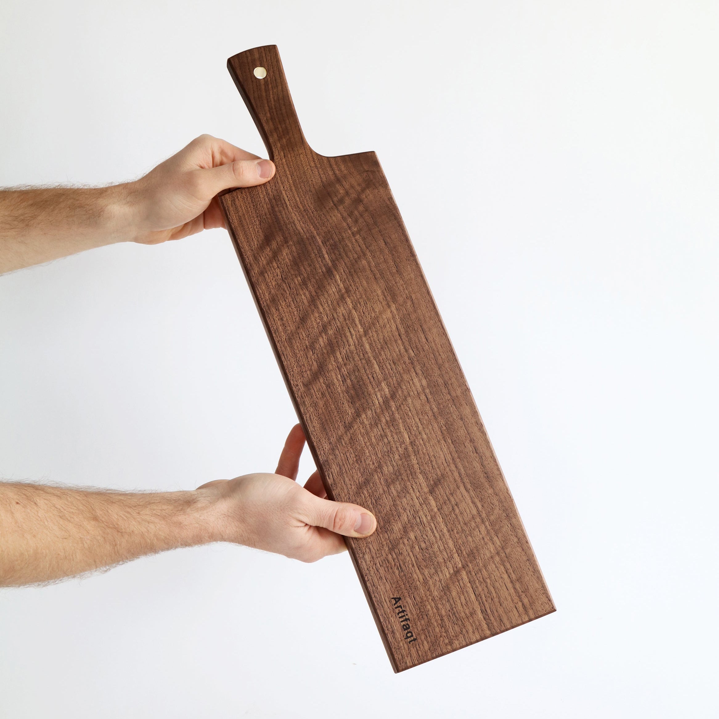 Wooden cutting board held by a person on a white background