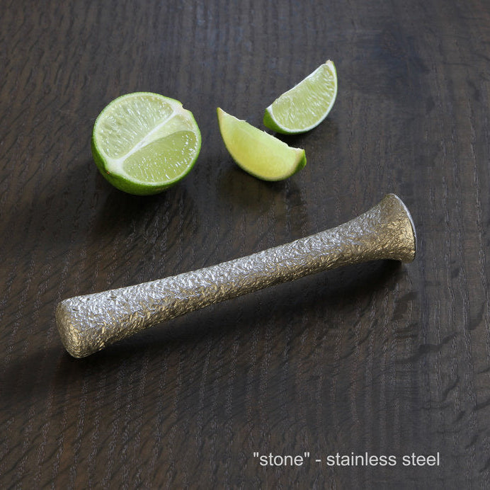 Stainless steel bar with lime wedges on a dark wooden surface