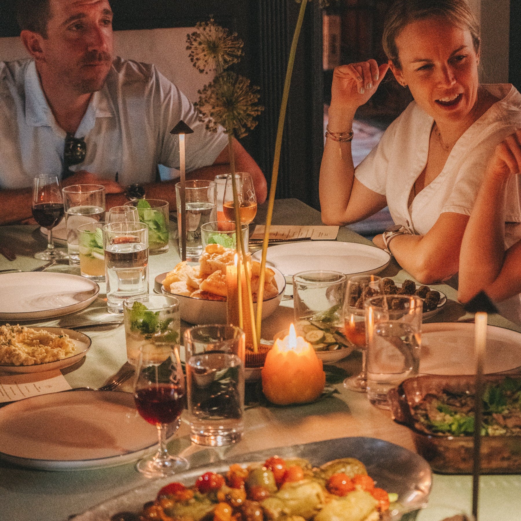 Two people enjoying a meal at a restaurant with a focus on the food.