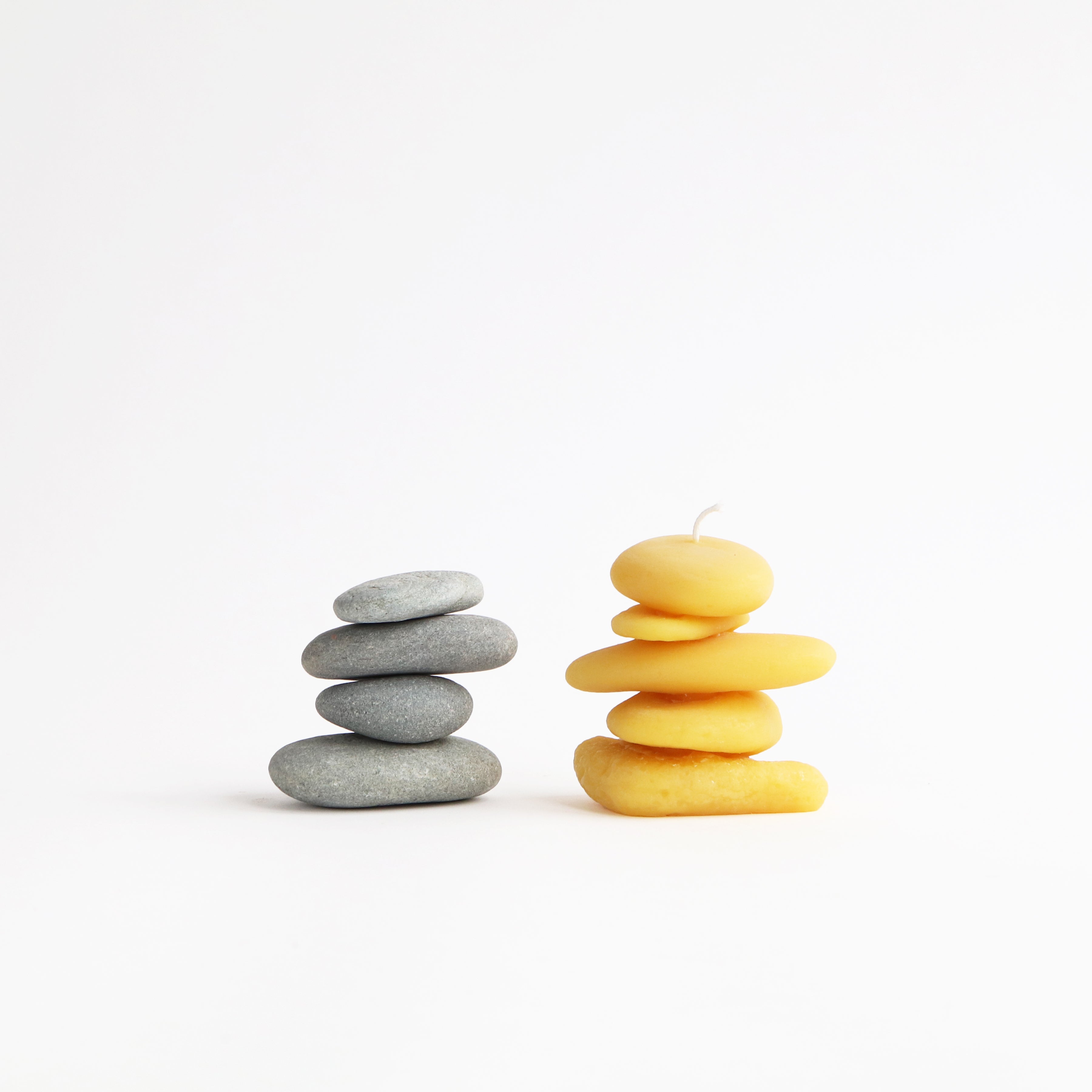 cairn beeswax candle next to real stone cairn