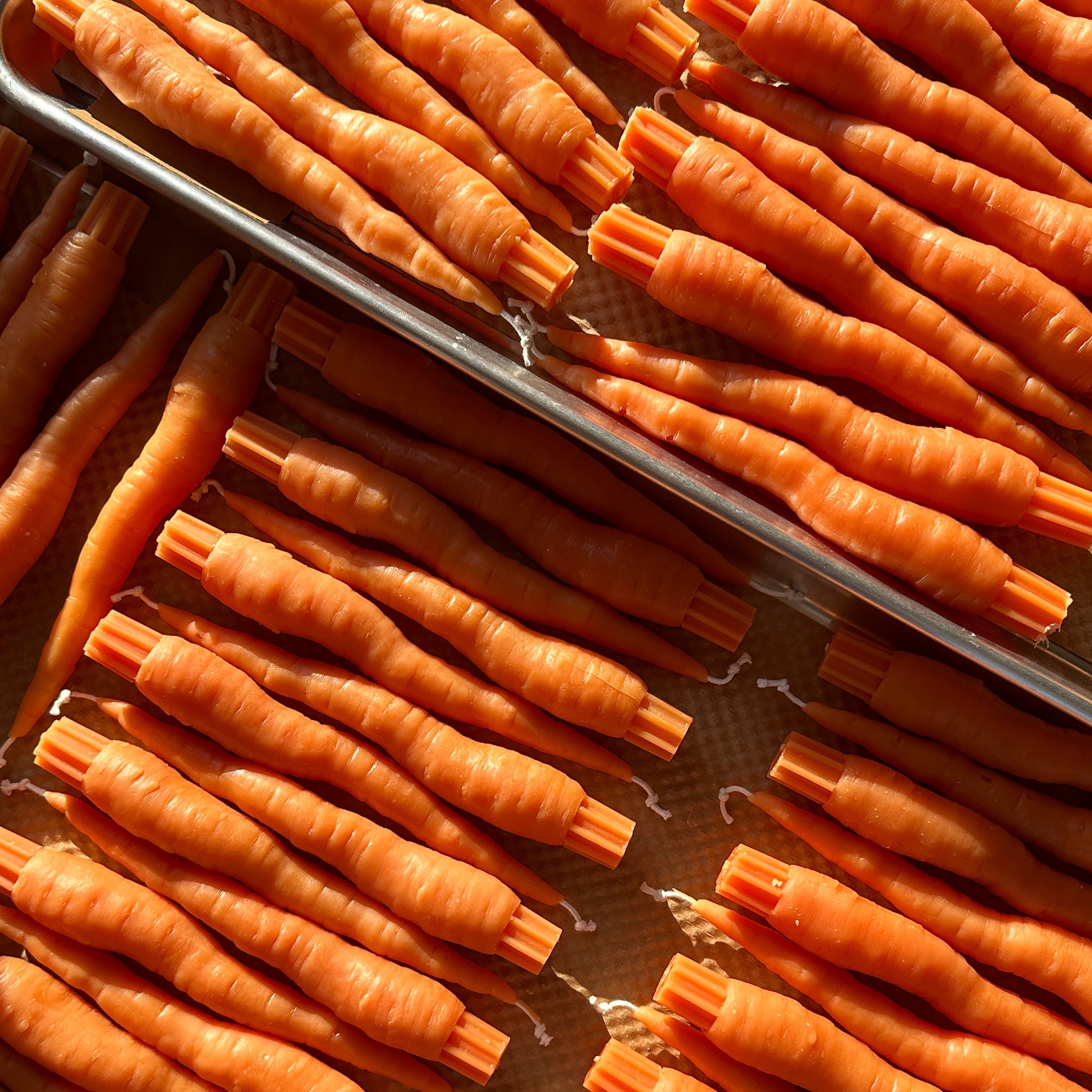 tray of orange carrot taper candles