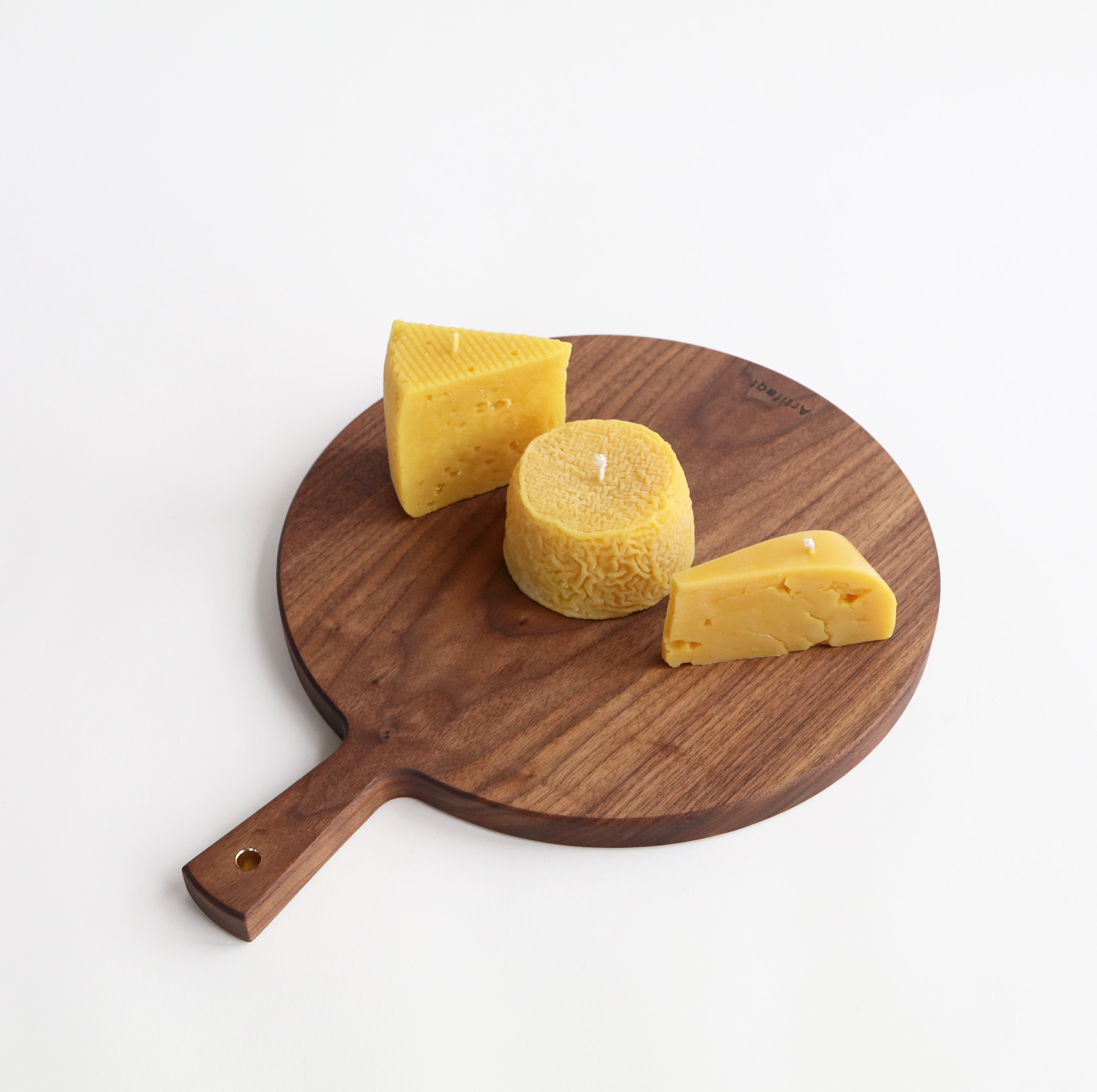 three cheese candles on a walnut charcuterie board