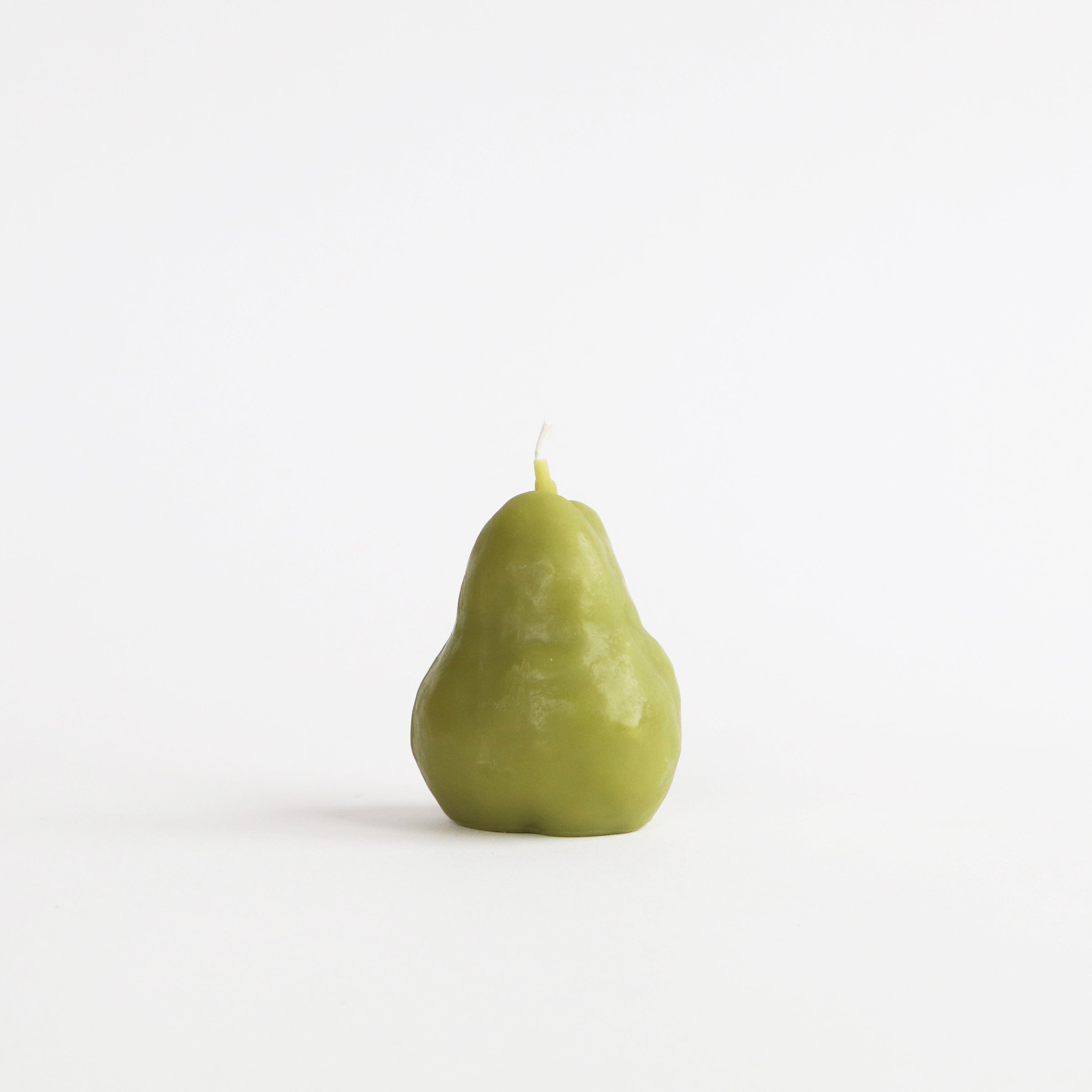 Green pear-shaped candle on a white background