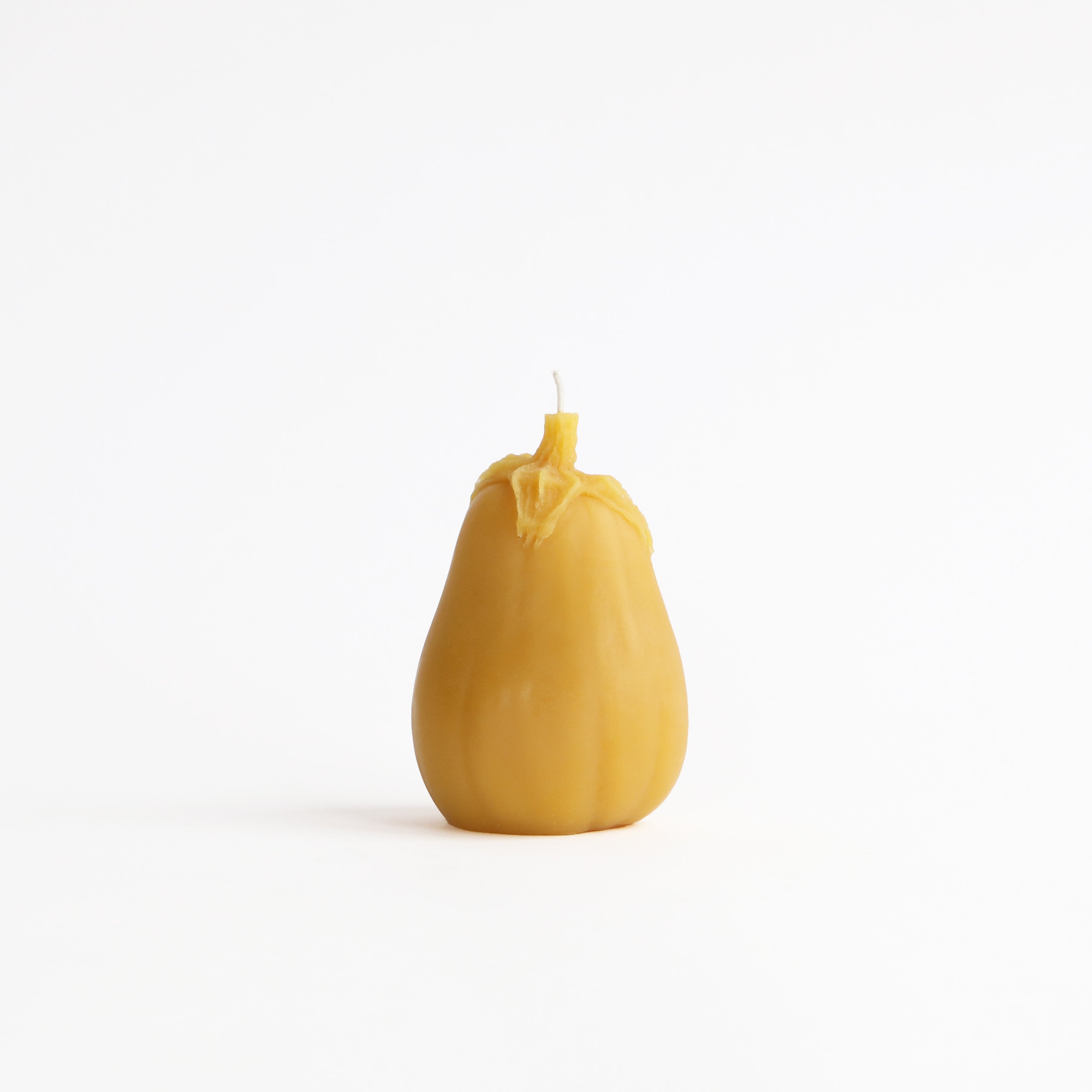 Yellow eggplant candle on a white background