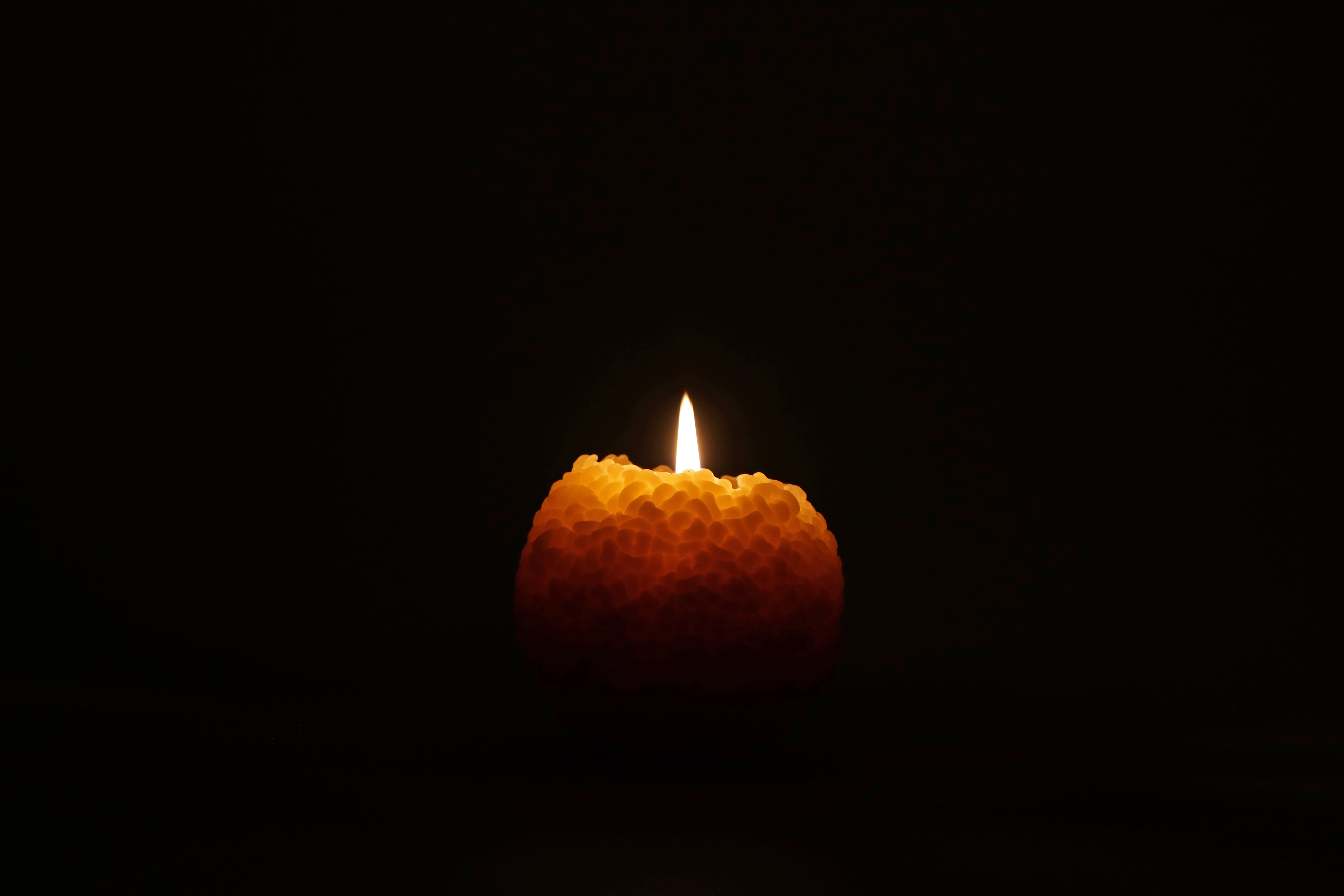 Candle with a single flame against a black background