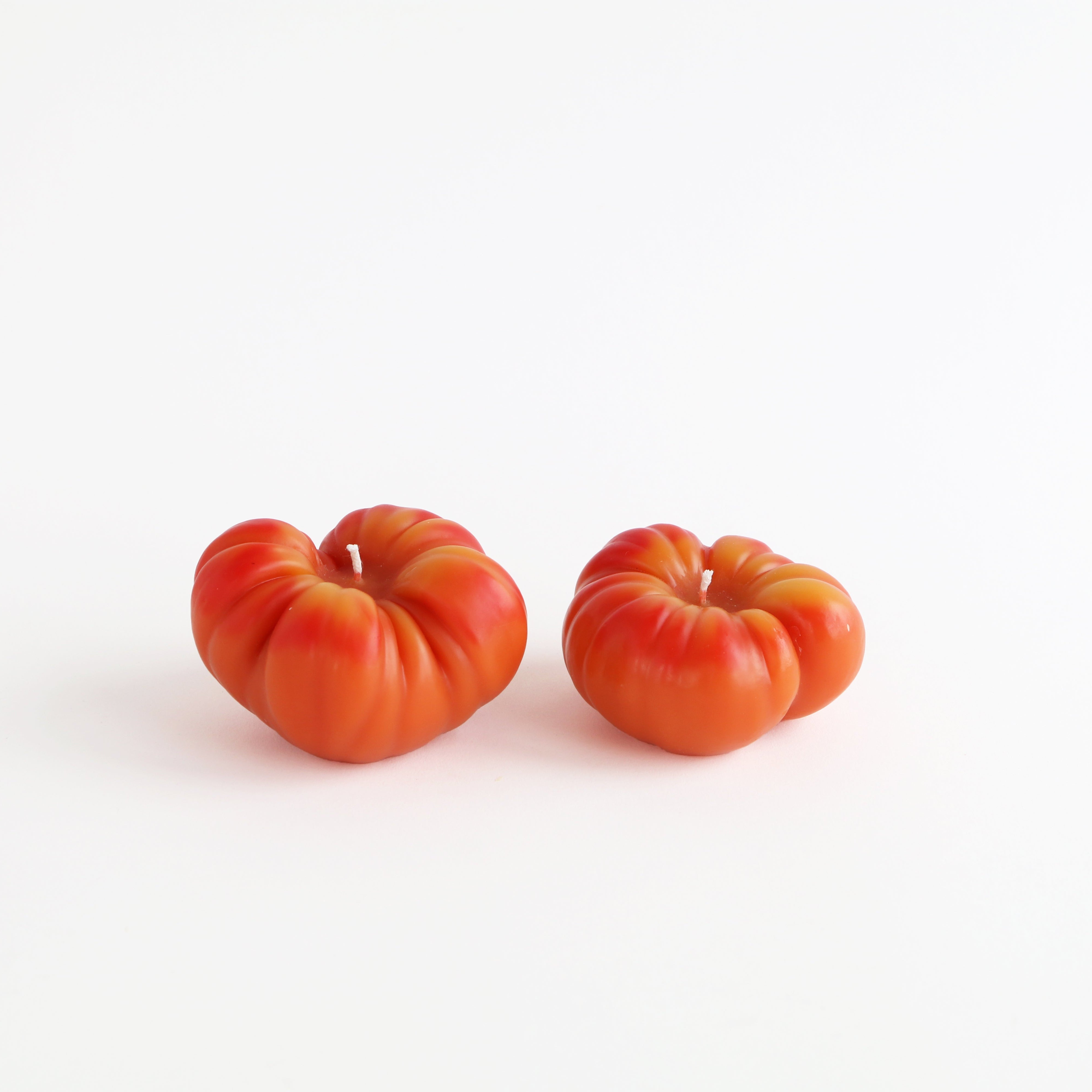 large and small orange tomato candles