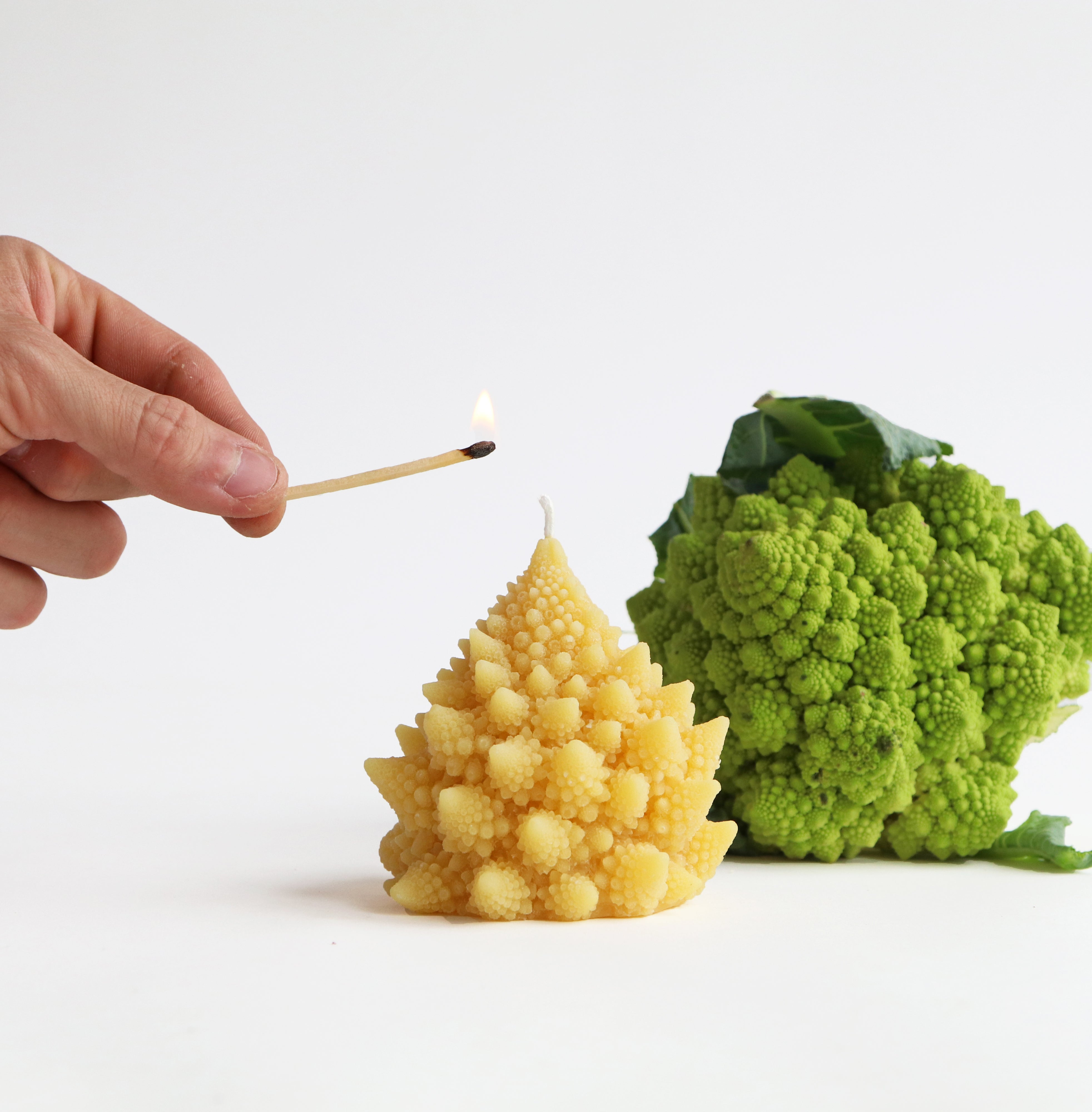 hand lighting romanesco candle with match