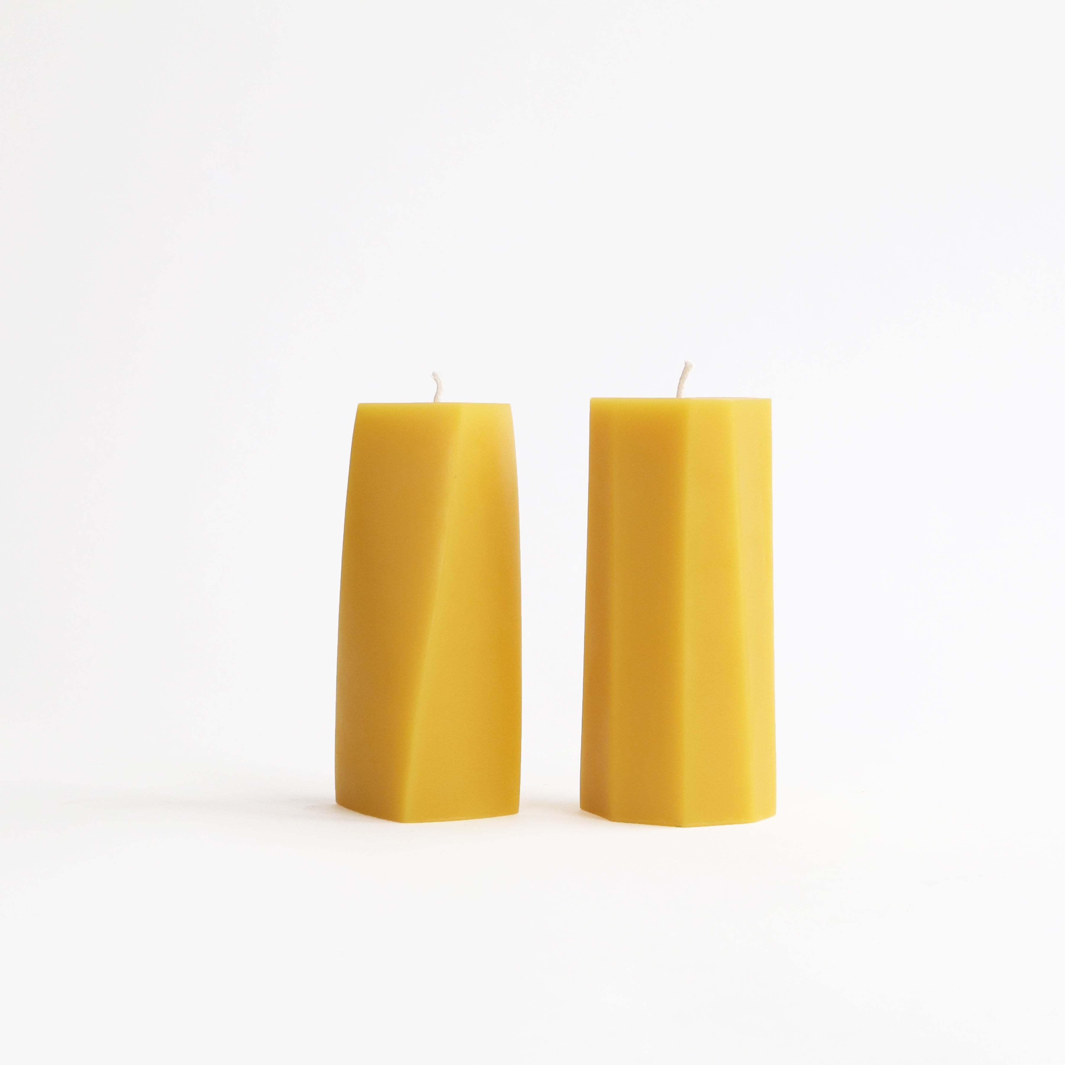 Two beeswax candles on a white background