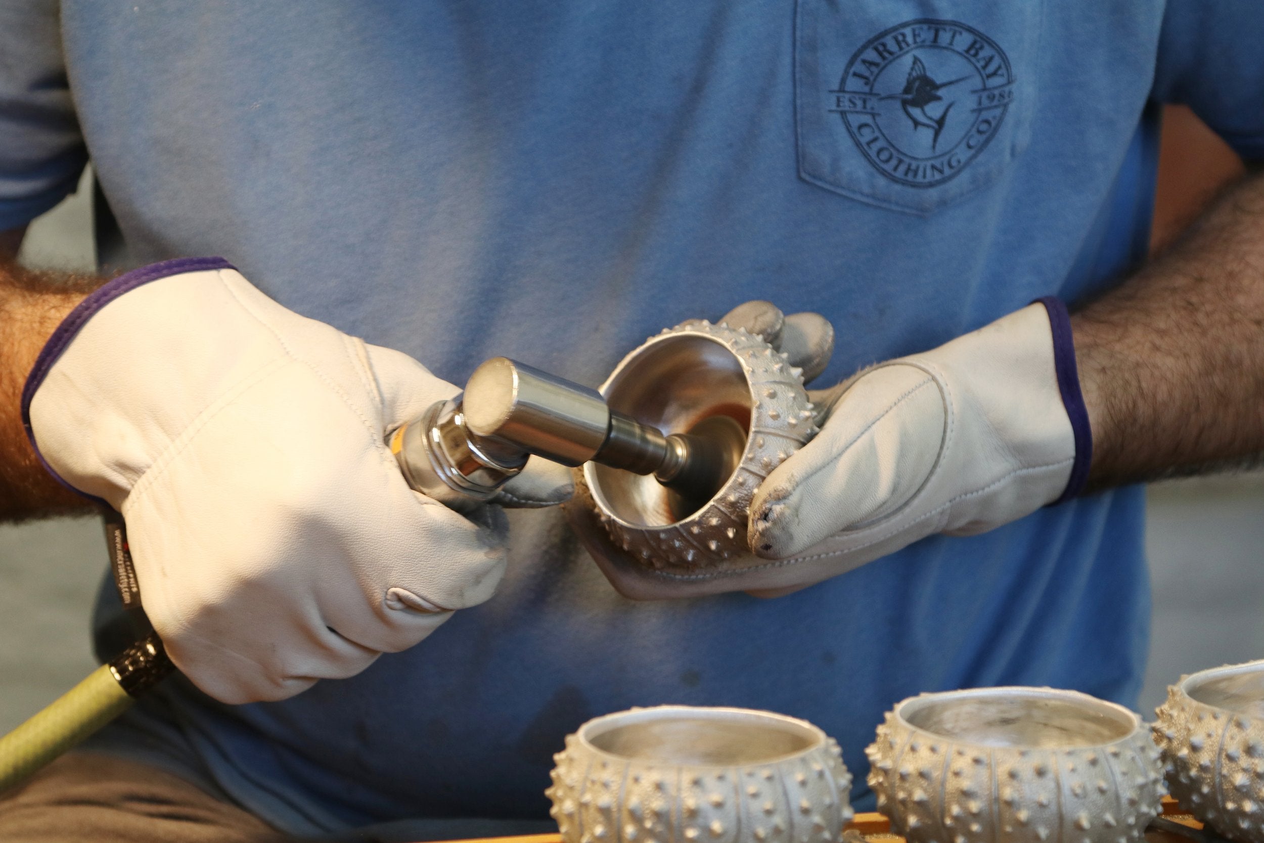 hands polishing silver sea urchin bowl