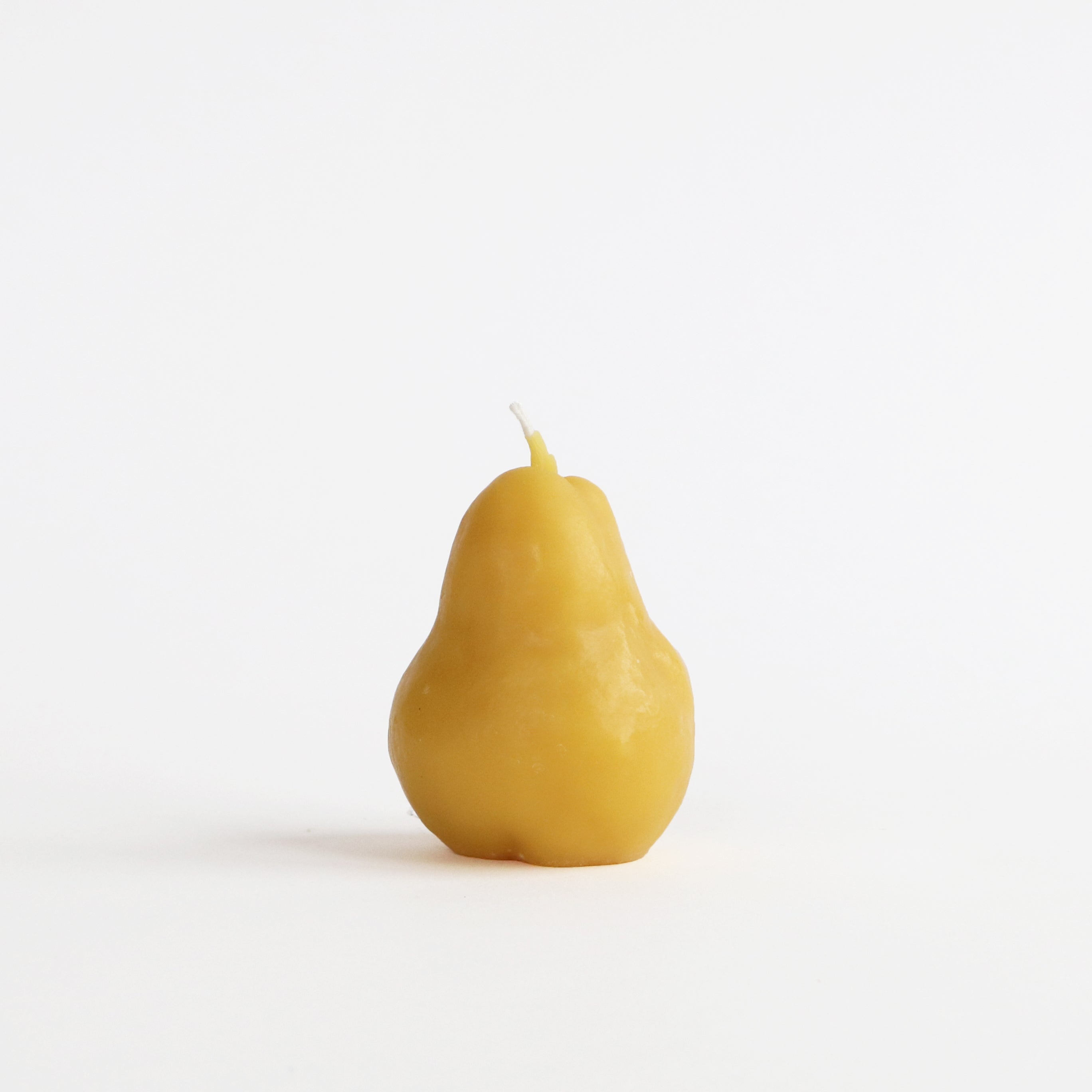 Pear-shaped candle on a white background